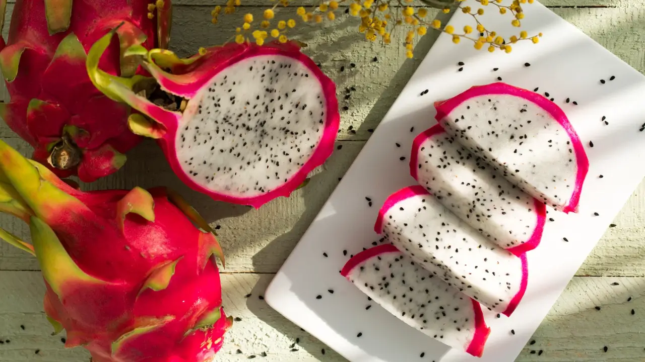 Pitaya partida ao meio e cortada em fatias, destacando sua polpa rica em antioxidantes e benefícios da Pitaia para a saúde