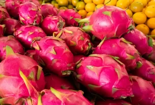 Pitayas vermelhas dispostas na feira, com casca brilhante e atraente, prontas para a venda.