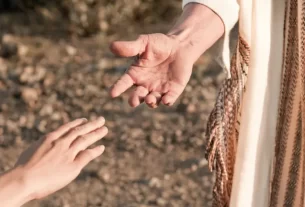 Tu me amas: um gesto de compaixão e acolhimento, onde uma mão estende-se para ajudar outra, transmitindo amor e apoio incondicional.